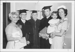 A graduate poses with President Dennis C. Haley, his family and faculty at the 1961 Suffolk University commencement