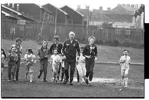 Gusty Spence jogging past Crumlin Road Jail with children shortly after his release from prison