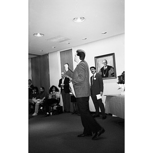 Unidentified man addressing attendees at a certificate presentation ceremony.