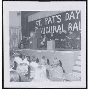 Ronald D. Young addresses an audience of children and men at a Boys' Club of Boston St. Patrick's Day inaugural ball and exercises event