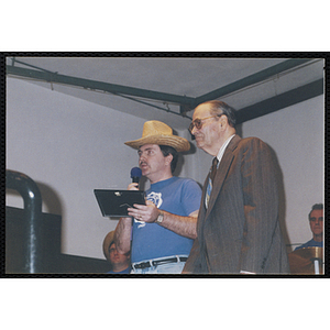 A Bunker Hillbilly alumnus speaks into a microphone as an elderly man looks on during a reunion event