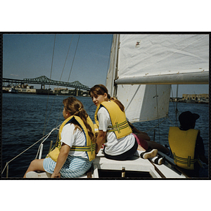 Two girls ride on a sailboat in Boston Harbor