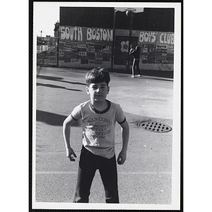 A boy from the South Boston day camp poses in the outdoor basketball court
