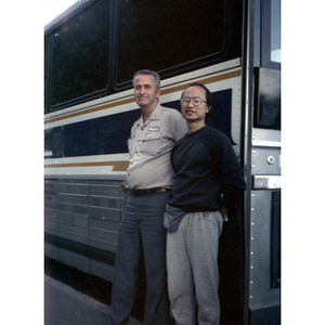 Chinese Progressive Association member stands outside of a charter bus with the bus driver