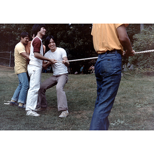 Young men play tug-of-war during an Association picnic