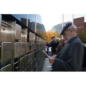 A man looks at a pamphlet in front of the Veterans Memorial at the dedication ceremony