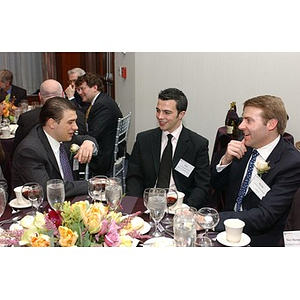 Three men converse at The National Council Dinner