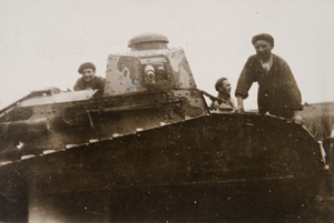 Three soldiers standing on a military tank