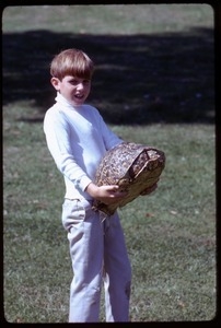 Son of Robert F. and Ethel Kennedy standing on the lawn with a large tortoise