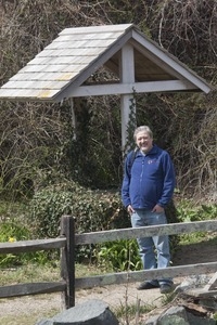 John Economos standing next to the water well at the Stony Brook Grist Mill and Museum