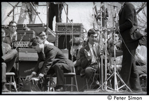 Resistance on the Boston Common: Staughton Lynd seated on the dais, reaching into a bag, Howard Zinn to his left clapping