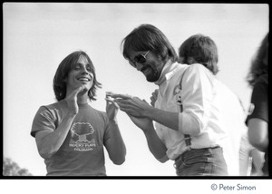 Jackson Browne (left) clapping on stage with Dan Fogelberg (?) at the No Nukes concert and protest, Washington, D.C.