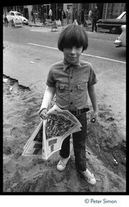 Young boy near Haight-Ashbury selling copies of the San Francisco Express Times underground newspaper