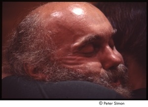 Close-up of Ram Dass embracing a man after a lecture at Boston University