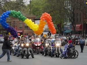 Contingent of motorcyclists under a rainbow array of balloons: Pride Parade; Main Street, Northampton, Mass.