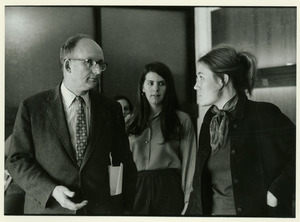 Robert C. Wood standing indoors and speaking with student