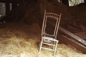Old wooden chair in hay pile in Moon Barn in the Moon Lot / Primmer Farm.