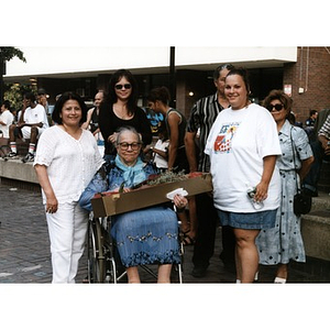 Older woman in a wheelchair holds a bouquet of flowers at Festival Betances 1999.