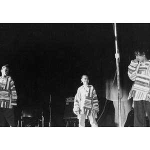 Three children performing on stage.