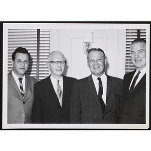 Board of Overseers members, including A. Boyd Hinds and William J. Lynch, standing second and third from left at a Boys' Club meeting