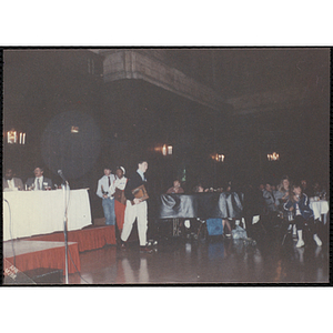 Jason Gallagher holding a plaque and walking past the head table during the "Recognition Dinner at Harvard Club"