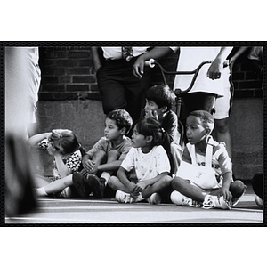 Children sit courtside and watch a Chelsea Housing Authority Basketball League game