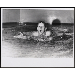 A boy swims in a natatorium pool
