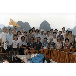 Association members pose in a group in front of part of the Guilin landscape while touring China