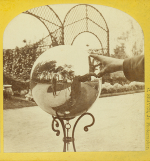 Stereograph self-portrait in a garden gazing ball, Ridge Hill Farms, Baker Estate, Wellesley, Mass., undated