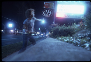 Double exposure of man by motel sign at night