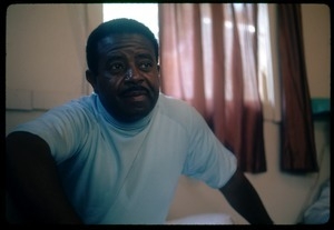 Rev. Ralph Abernathy seated on a hotel room bed