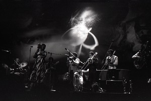 Taj Mahal in concert at Northfield, Mass.: Taj Mahal and horn section with light show behind