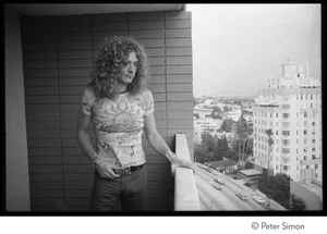 Robert Plant (Led Zeppelin) looks at Sunset Strip from a balcony at the Riot House, hand resting on the railing