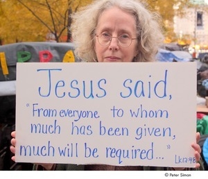 Occupy Wall Street: demonstrator holding sign reading, 'Jesus said, from everyone, to whom much has been given, much will be required'