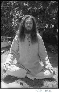 Gangadhar: portrait of the tabla player with Amazing Grace and member of Ram Dass satsang, seated in a lotus position in front of a rhododendron