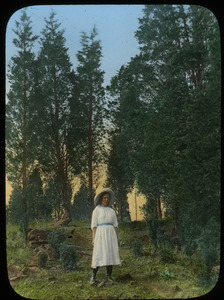 Girl standing front of (Juniper?) trees