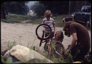 Eben Light, Sequoya Frey, and Benny repairing a bicycle, Montague Farm Commune