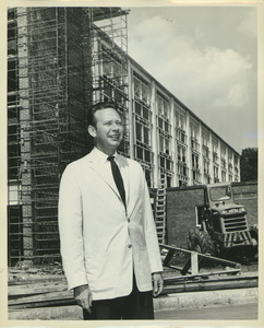 Fred Virgil Cahill standing outdoors in front of Bartlett Hall during its construction