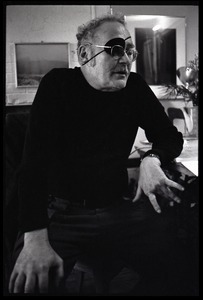 W. Eugene Smith, seated at a desk in his home