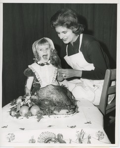 Barbara Berkoff feeding turkey to Susie Renken
