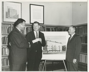 Norman Salatini shaking hands with Willis C. Gorthy in front of prospective building plans