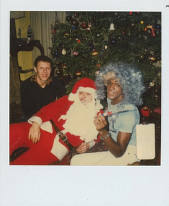 Photographs of Marsha P. Johnson Wearing Tinsel on Her Head, Posing with Others by a Christmas Tree