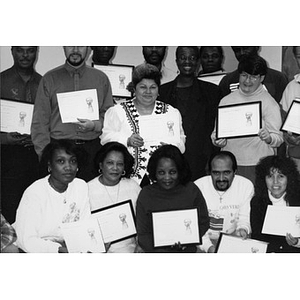 Group portrait of people with framed certificates in their hands, detail.