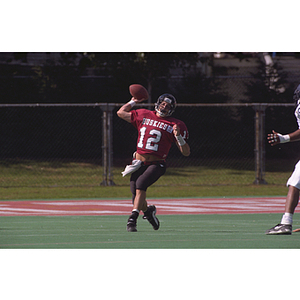 Northeastern football player throwing football during a game