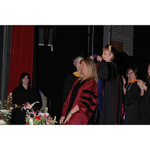 Carole Kenner presents a student with a sash at the School of Nursing convocation