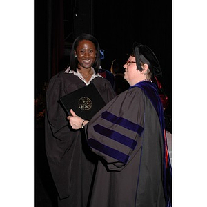 Faculty member presents student with certificate at School of Nursing convocation