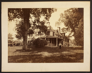 Informal portrait of an unidentified man standing on the front lawn of the Boylston House, Fisher Hill