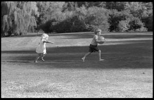 Children chasing around with a ball on Cambridge Common