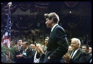 Robert F. Kennedy on the campaign trail, walking into a packed auditorium, while stumping for candidates in the northern Midwest