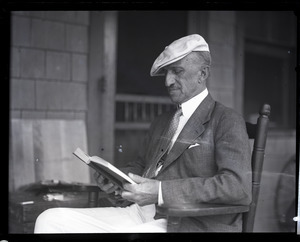 Uncle Joe Holland, seated on a porch, reading a book